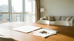 Appartement lumineux prêt à louer avec un dossier administratif aux pages vierges et des clés posés sur une table en bois.