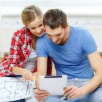 LGM immobilier : préparer son projet avant le premier rendez-vous Un couple examine des plans de maison et des documents immobiliers avant son premier rendez-vous avec LGM Immobilier.